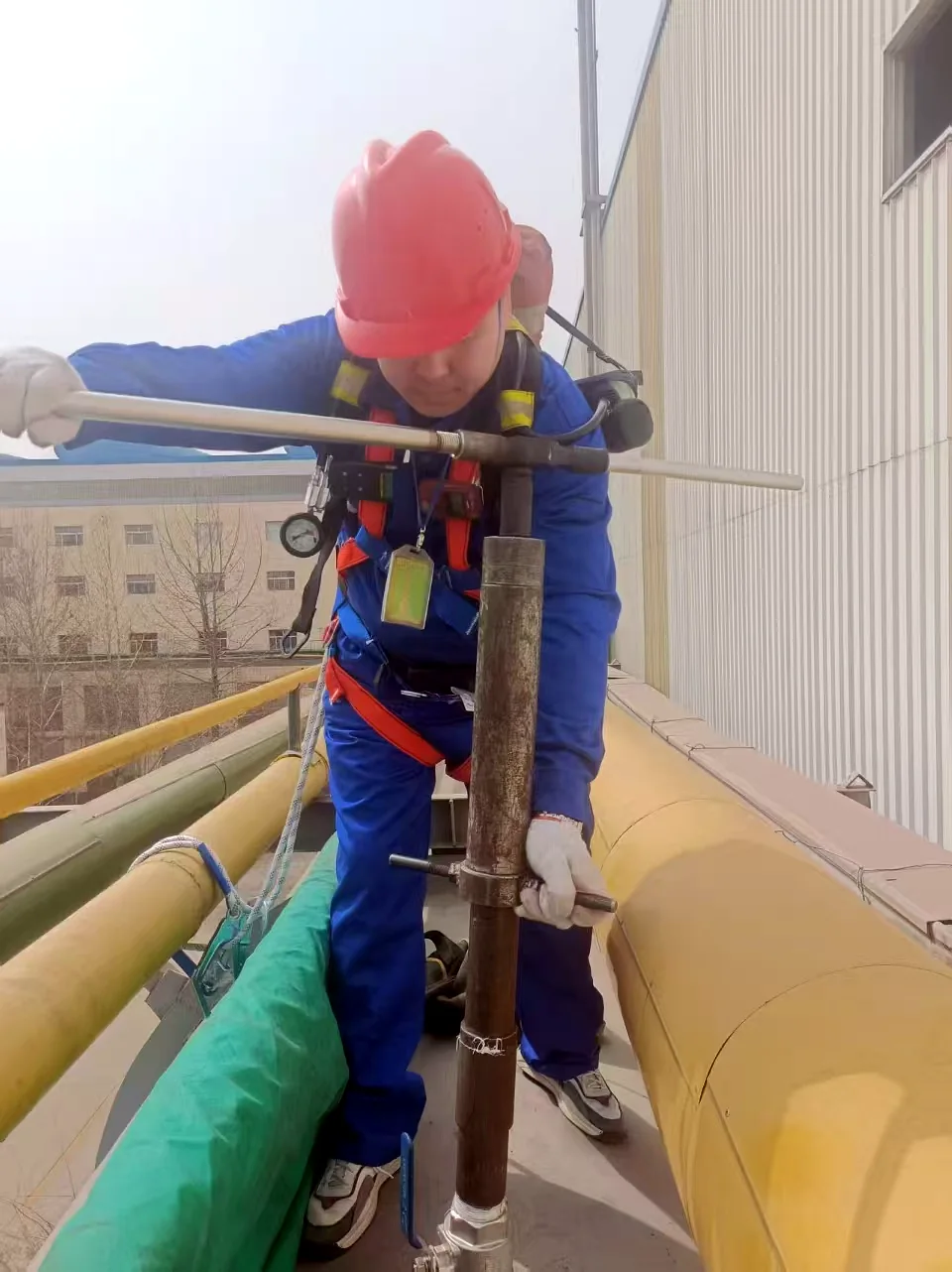 Technician carrying out an online hot-tap installation on an industrial pipeline
